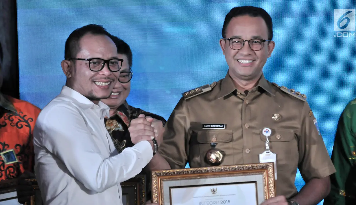 Gubernur DKI Jakarta Anies Baswedan (kanan) menerima penghargaan dari Menteri Ketenagakerjaan Hanif Dhakiri (kiri) dalam Indeks Pembangunan Ketenagakerjaan (INTEGRA) 2018 di Kantor Kemnaker, Jakarta, Senin (19/11). (Merdeka.com/Iqbal Nugroho)