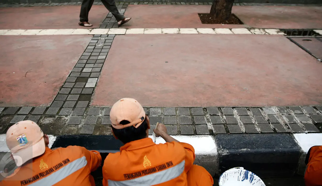 Petugas dari Kelurahan Karet Semanggi mengecat trotoar di kawasan Jalan Semanggi, Jakarta, Selasa (1/3/2016). Trotoar itu dipercantik dengan dicat ulang oleh Petugas Prasarana Sarana Umum (PPSU). (Liputan6.com/Faizal Fanani)