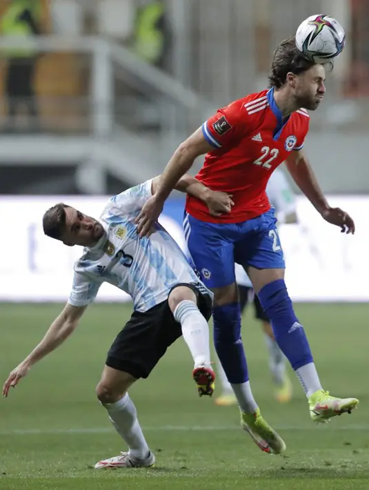 Pemain Argentina Nicolas Tagliafico (kiri) berebut bola dengan pemain Chile Ben Brereton (tengah) pada pertandingan sepak bola Kualifikasi Piala Dunia 2022 di Stadion Zorros del Desierto, Calama, Chile, 27 Januari 2022. Argentina menang 2-1. (Javier Torres/POOL/AFP)