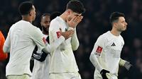 Gelandang Arsenal, Kai Havertz (tengah), menutupi wajahnya setelah timnya kalah dalam adu penalti dari Manchester United pada babak ketiga Piala FA 2024/2025 di Stadion Emirates, London, Senin (13/1/2025) dini hari WIB. (AFP/Glyn Kirk)
