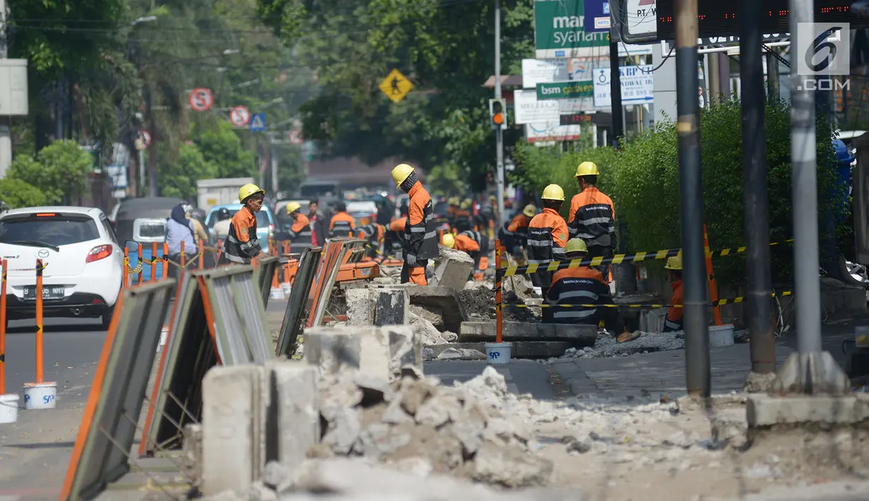 Pekerja membongkar trotoar lama di Jalan Cikini Raya, Taman Ismail Marzuki (TIM), Jakarta, Selasa (18/6/2019). Revitalisasi trotoar TIM hingga Jalan Diponegoro ditargetkan rampung pada Desember 2019. (merdeka.com/Imam Buhori)