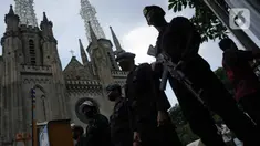 Personel Brimob melakukan penjagaan saat penyisiran di Gereja Katedral, Jakarta, Jumat (24/12/2021). Polda Metro Jaya bersama Satuan Brimob melakukan sterilisasi sejumlah gereja guna memastikan bebas dari bahan berbahaya. (Liputan6.com/Faizal Fanani)