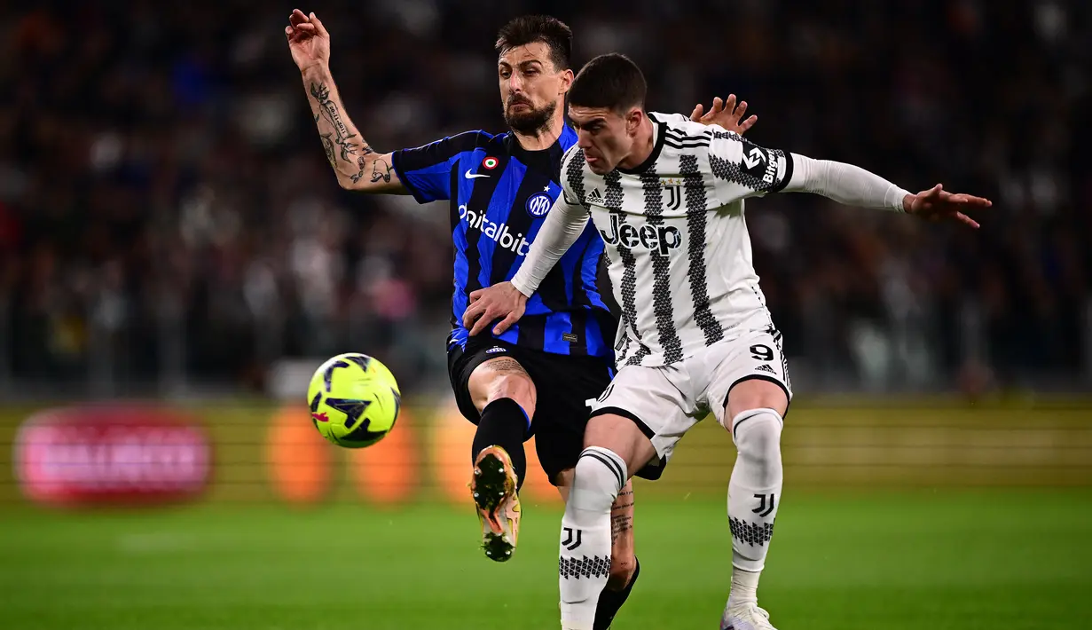 Striker Juventus, Dusan Vlahovic (kanan) berebut bola dengan bek Inter Milan, Francesco Acerbi pada laga leg pertama semifinal Coppa Italia 2022/2023 di Allianz Stadium, Turin, Rabu (5/4/2023) dini hari WIB. (AFP/Marco Bertorello)