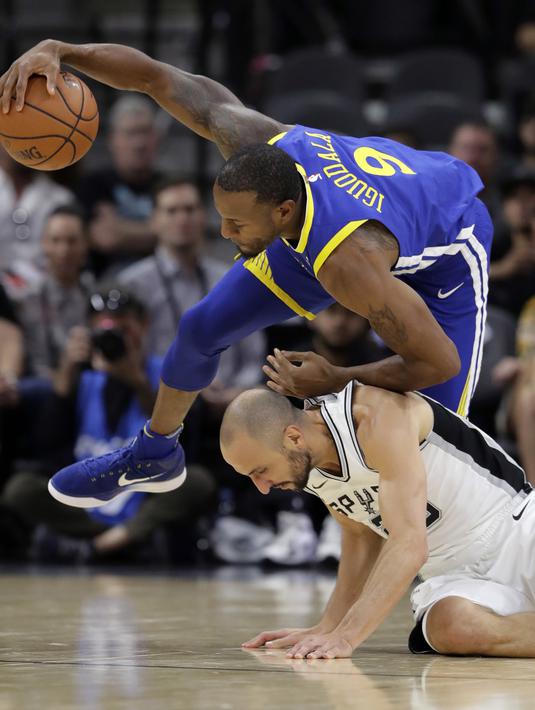 Pemain Warriors, Andre Iguodala (atas) berebut bola dengan pemain Spurs, Manu Ginobili (bawah) pada laga NBA basketball game di AT&T Center, San Antonio, (2/11/2017) waktu setempat. Warriors menang 112-92. (AP/Eric Gay)