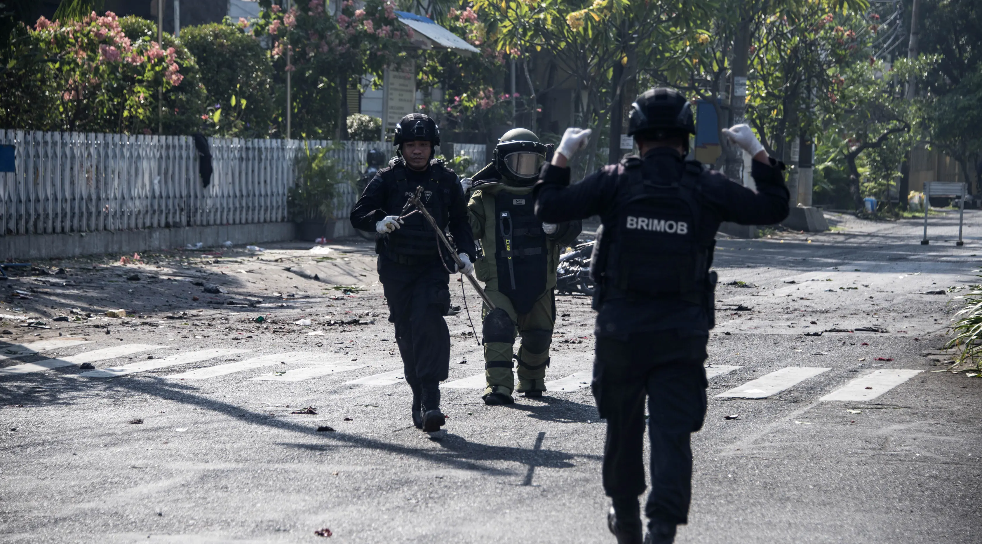Tim gegana Brimob Jawa Timur melakukan penyisiran di sekitar gereja di Surabaya menyusul ledakan bom, Minggu (13/5). Ledakan terjadi di tiga gereja, yakni Santa Maria di Ngagel, GKI di Jalan Diponegoro dan gereja di Jalan Arjuna. (AFP/JUNI KRISWANTO)