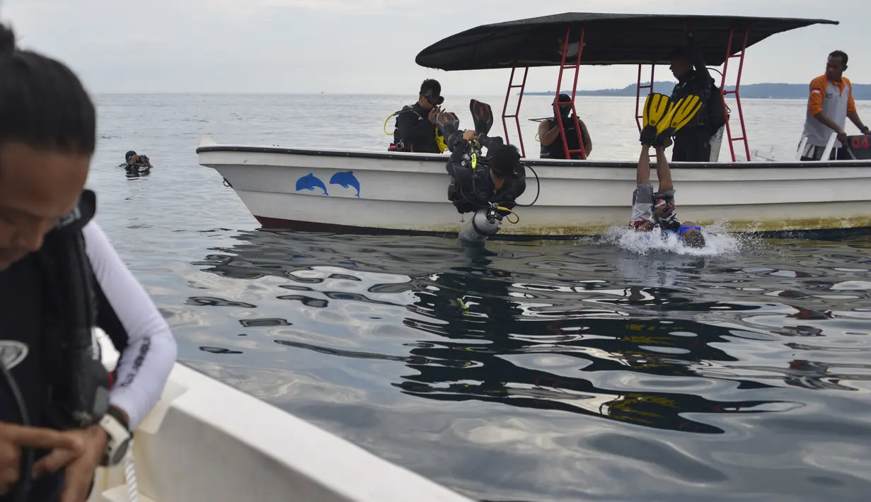 Wisatawan melompat ke air untuk menyelam scuba di lokasi penyelaman di Iboih, taman pantai dan pariwisata yang populer di seberang teluk dari Sabang di pulau Weh, provinsi Aceh (6/10/2019). (AFP Photo/Chaideer Mahyuddin)
