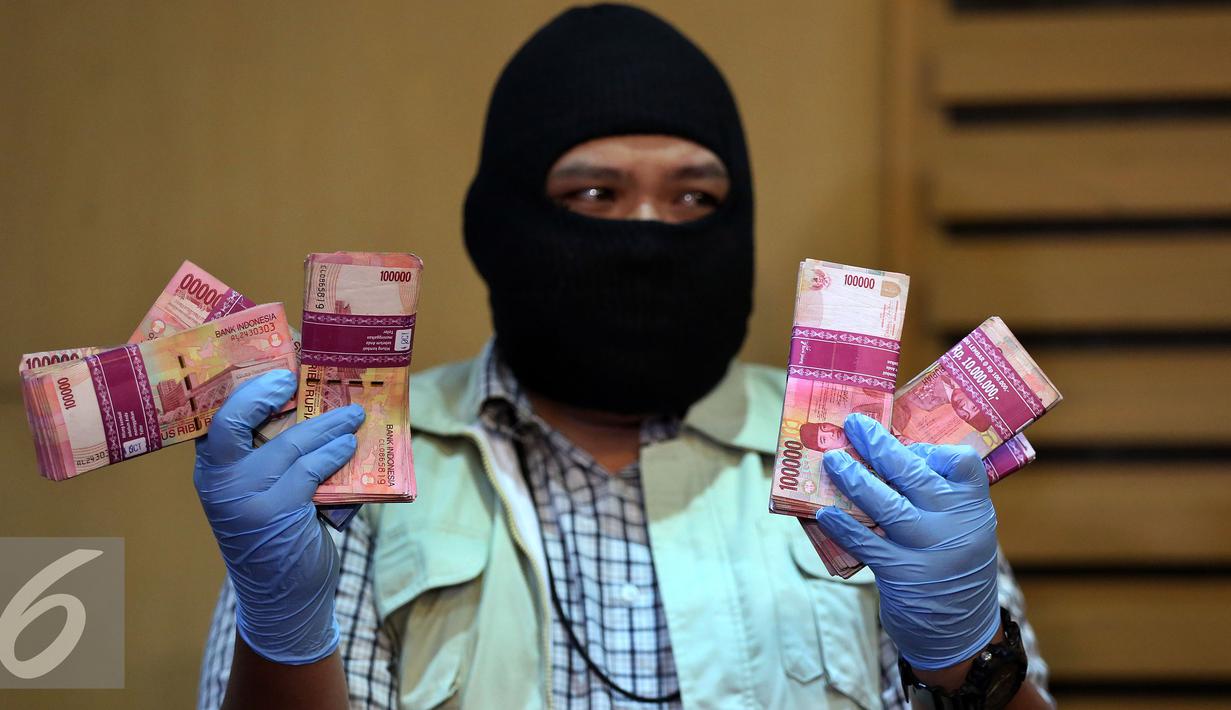 KPK memperlihatkan uang hasil Operasi tangkap tangan (OTT) terhadap Anggota DPRD Kabupaten Kebumen Suhartono (SGW) di rumahnya Jalan Cincin Kota RT 5 RW 3 di Kebumen-Jawa Tengah, Jakarta, Minggu (16/10). (Liputan6.com/Johan Tallo)