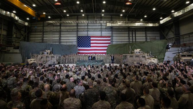 Presiden Amerika Serikat Donald Trump berbicara kepada anggota militer saat mengunjungi Pangkalan Udara Bagram, Afghanistan, Kamis (28/11/2019). Kunjungan dadakan Trump pada hari Thanksgiving tersebut mengejutkan pasukan AS yang bertugas di Afghanistan. (AP Photo/Alex Brandon)