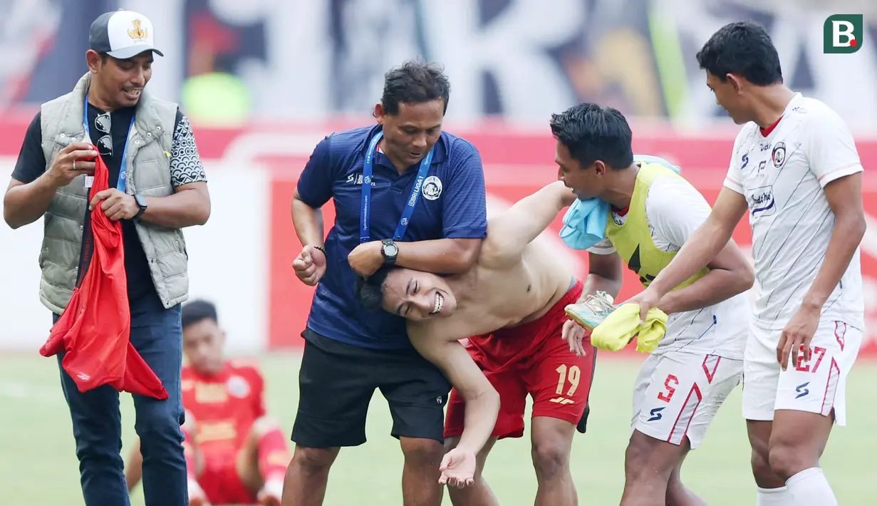 Pemain Persija Jakarta, Hanif Sjahbandi, bercanda dengan staf pelatih dan pemain Arema FC pada lanjutan BRI Liga 1 2023/2024 di Stadion Patriot Chandrabhaga, Kota Bekasi, Minggu (20/08/2023). Kedua tim bermain imbang 2-2. (Bola.com/M Iqbal Ichsan)