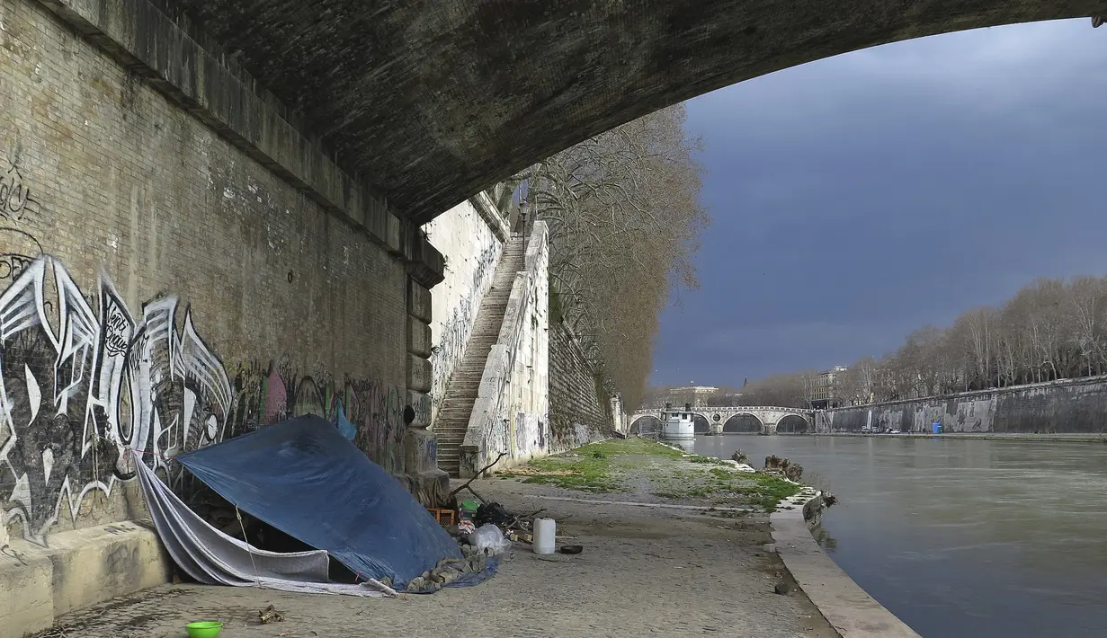Kondisi sebuah tenda tunawisma terlihat di kawasan permukiman kumuh bawah jembatan di Sungai Tiber, Roma, Italia (13/4). Para tunawisma menggunakan kayu, karton, hingga terpal plastik untuk membuat tenda sebagai tempat tinggalnya. (REUTERS / Max Rossi)