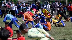 Siswa mengikuti permainan tradisional tarik upih pinang (tarek situek) pada Festival Permainan Tradisional Anak di Desa Wisata Lubok Sukon, Kecamatan Ingin Jaya, Aceh Besar, Aceh, Sabtu (25/7/2026). (AFP/ Chaideer Mahyuddin)