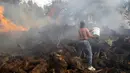 Seorang penduduk setempat menggunakan ember untuk mencoba menghentikan kebakaran hutan yang mencapai rumah-rumah di Desa Figueiras, di luar Leiria, Portugal, 12 Juli 2022. Ratusan petugas pemadam kebakaran di Portugal terus memadamkan api di pusat negara yang memaksa evakuasi puluhan orang dari rumah mereka sebagian besar di desa-desa sekitar Santarem, Leiria, dan Pombal. (AP Photo/Joao Henriques)