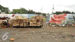 Warga merapihkan peti buah di samping lokasi pembangunan pusat perkulakan, Pasar Induk, Kramat Jati, Jakarta, Senin (16/1). Sebelumnya, pembangunan pusat perkulakan ini ditargetkan selesai pada Desember 2016 atau Januari 2017. (Liputan6.com/Yoppy Renato)