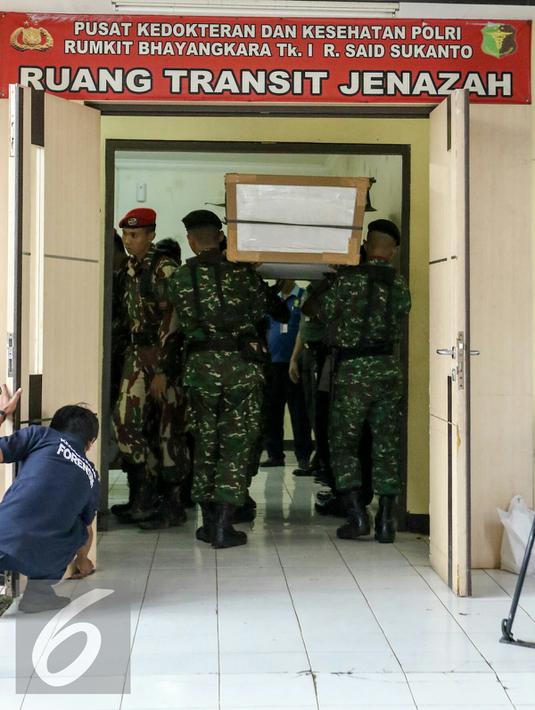Petugas mengangkat  peti ke ruang transit jenazah yang dipersiapkan untuk korban helikopter TNI yang jatuh di RS Polri, Jakarta, Senin (21/3). Helikopter TNI AD mengalami kecelakaan saat akan mendarat di stadion Poso. (Liputan6.com/Yoppy Renato)