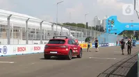 Sejumlah pembalap beserta kru tim peserta lomba balap mobil listrik Formula E melakukan persiapan dan driver track walk di lintasan sirkuit JIEC, Ancol, Pademangan, Jakarta Utara, Jumat (3/6/2022). Sesi driver track walk digunakan para pebalap dan kru untuk mengukur panjang lintasan serta adaptasi terhadap sirkuit.  (Liputan6.com/Herman Zakharia)