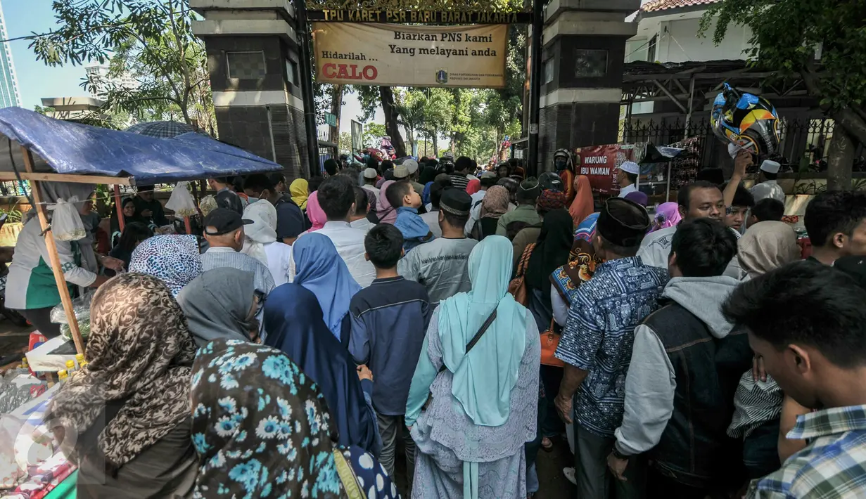 Peziarah berdesakan di pintu masuk TPU Karet Bivak, Jakarta, Rabu (6/7). Padatnya peziarah menyebabkan arus lalu lintas di depan TPU menjadi tersendat karena warga memarkir kendaraan di badan jalan. (Liputan6.com/Yoppy Renato)