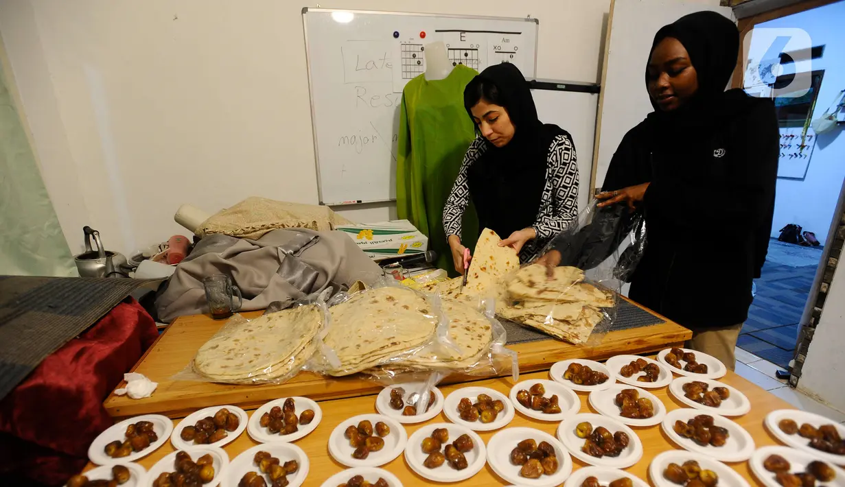 Dua pengungsi pencari suaka asal Irak dan Sudan menyiapkan makanan berbuka puasa di kawasan batulayang, Cisarua, Bogor, Minggu (9/4/2023). (merdeka.com/Arie Basuki)