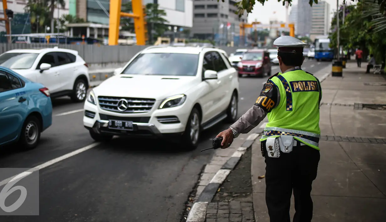 Petugas Polantas mengantur lalu lintas di kawasan Thamrin, Jakarta, Rabu (25/7). Kebijakan pembatasan kendaraan dengan penerapan pelat ganjil genap dimulai pada 27 Juli mendatang. (Liputan6.com/Faizal Fanani)