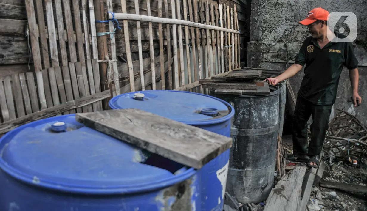 Warga menunjukkan drum untuk mengendapkan air sumur di kampung nelayan Kalibaru, Cilincing, Jakarta Utara, Selasa (22/3/2022). Sementara untuk kebutuhan MCK, warga tetap menggunakan air sumur yang diendapkan terlebih dahulu. (merdeka.com/Iqbal S Nugroho)