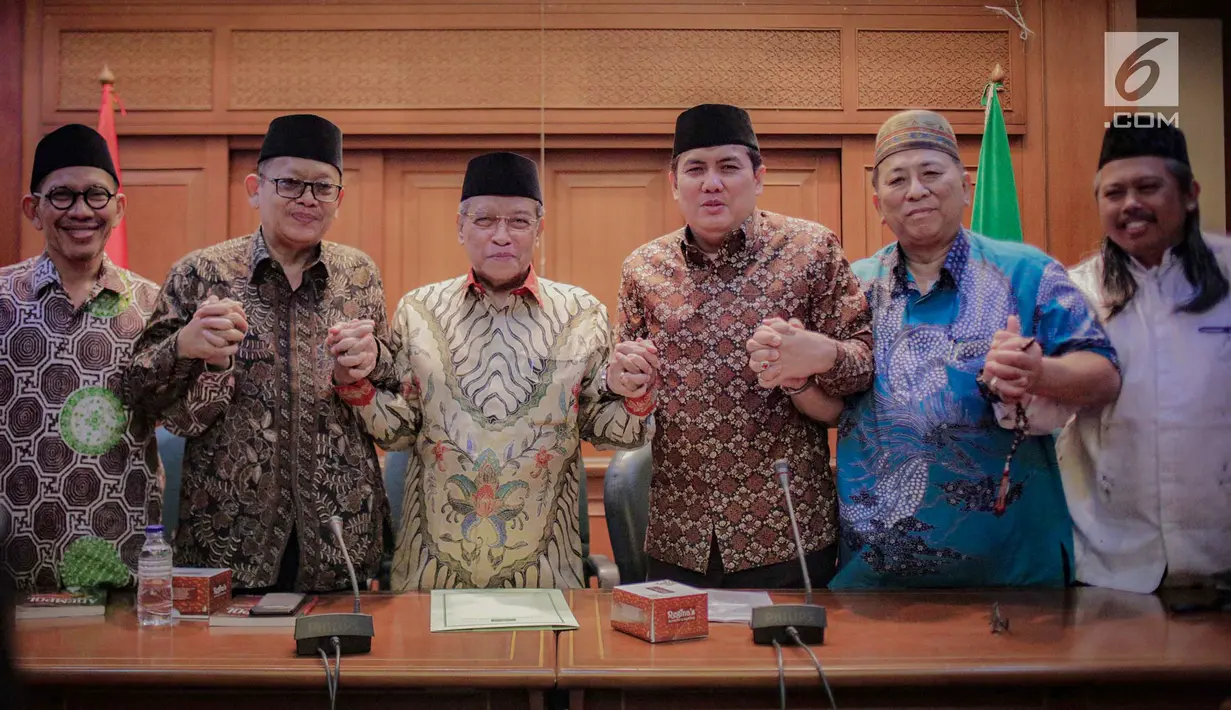 Ketua Umum PBNU Said Aqil Siradj (tiga kiri) foto bersama dengan sejumlah pengurus lainnya usai konferensi pers terkait Pemilu 2019 di Kantor PBNU, Jakarta, Senin (15/4). PBNU mengimbau masyarakat tak Golput dalam Pemilu 2019. (Liputan6.com/Faizal Fanani)