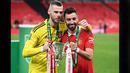 <p>Pemain Manchester United, David De Gea (kiri) dan Bruno Fernandes berpose bersama trofi Carabao Cup 2023 setelah mengalahkan Newcastle United di Wembley Stadium, Minggu (26/2/2023) waktu setempat. (AFP/Glyn Kirk)</p>
