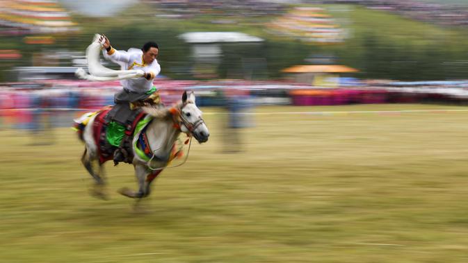 Seorang penunggang kuda memamerkan kemampuannya dalam upacara pembukaan Festival Pariwisata Shambhala ke-20 di Prefektur Otonom Etnis Tibet Gannan, Provinsi Gansu, China, 31 Agustus 2020. Festival Pariwisata Shambhala ke-20 dimulai di Padang Rumput Dangzhou pada Senin (31/8). (Xinhua/Chen Bin)