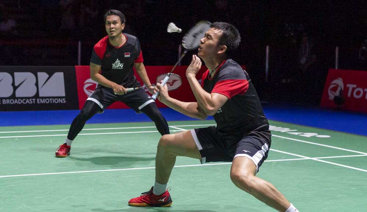 Pasangan Indonesia, Hendra Setiawan/Mohammad Ahsan saat melawan wakil Jepang, Takuro Hoki/Yugo Kobayashi, pada Kejuaraan Dunia Bulutangkis 2019 di Swiss, Minggu (25/8). Indonesia menang 25-23, 9-21, 21-15. (AP/Georgios Kefalas)