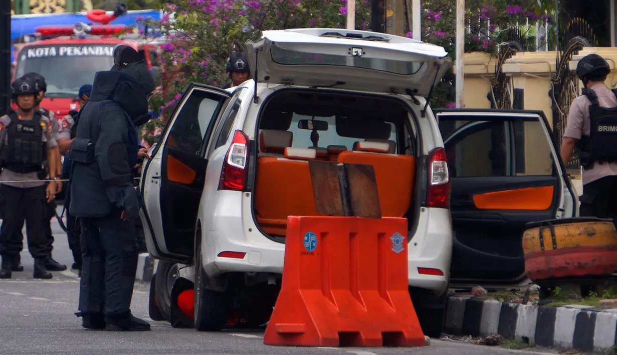 Anggota regu penjinak bom memeriksa sebuah minibus yang digunakan dalam serangan di Mapolda Riau Rabu (16/5). (AP Photo/Akbari)