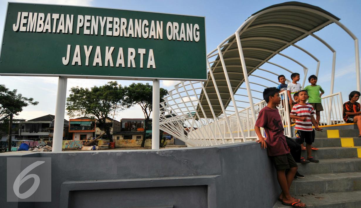 Sejumlah anak-anak bermain di atas JPO Jayakarta, Manggarai, Jakarta, Rabu (27/4/2016). JPO yang menghubungkan Menteng Tenggulun dan Manggarai tersebut dibangun untuk menggantikan transportasi perahu eretan. (Liputan6.com/Yoppy Renato)