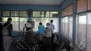 Sejumlah petugas KNKT sedang melakukan pemeriksaan serpihan pesawat AirAsia QZ8501 di posko DVI Lanud TNI AU Iskandar, Pangkalan Bun, Selasa (6/1/15). (Liputan6.com/Herman Zakharia)