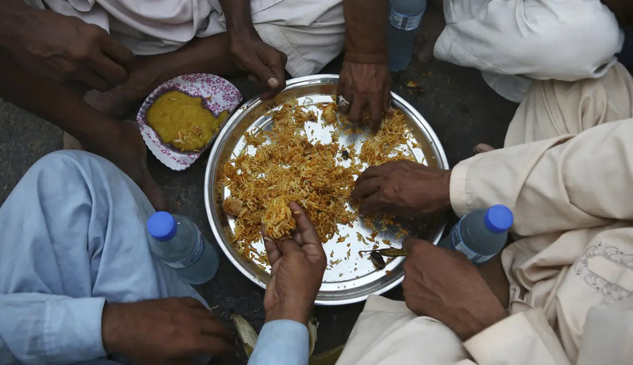Warga berbuka puasa bersama selama bulan suci Ramadan di Karachi, Pakistan, Selasa (12/5/2020). Warga berbuka puasa bersama setelah pemerintah melonggarkan lockdown terkait pandemi virus corona COVID-19. (AP Photo/Fareed Khan)