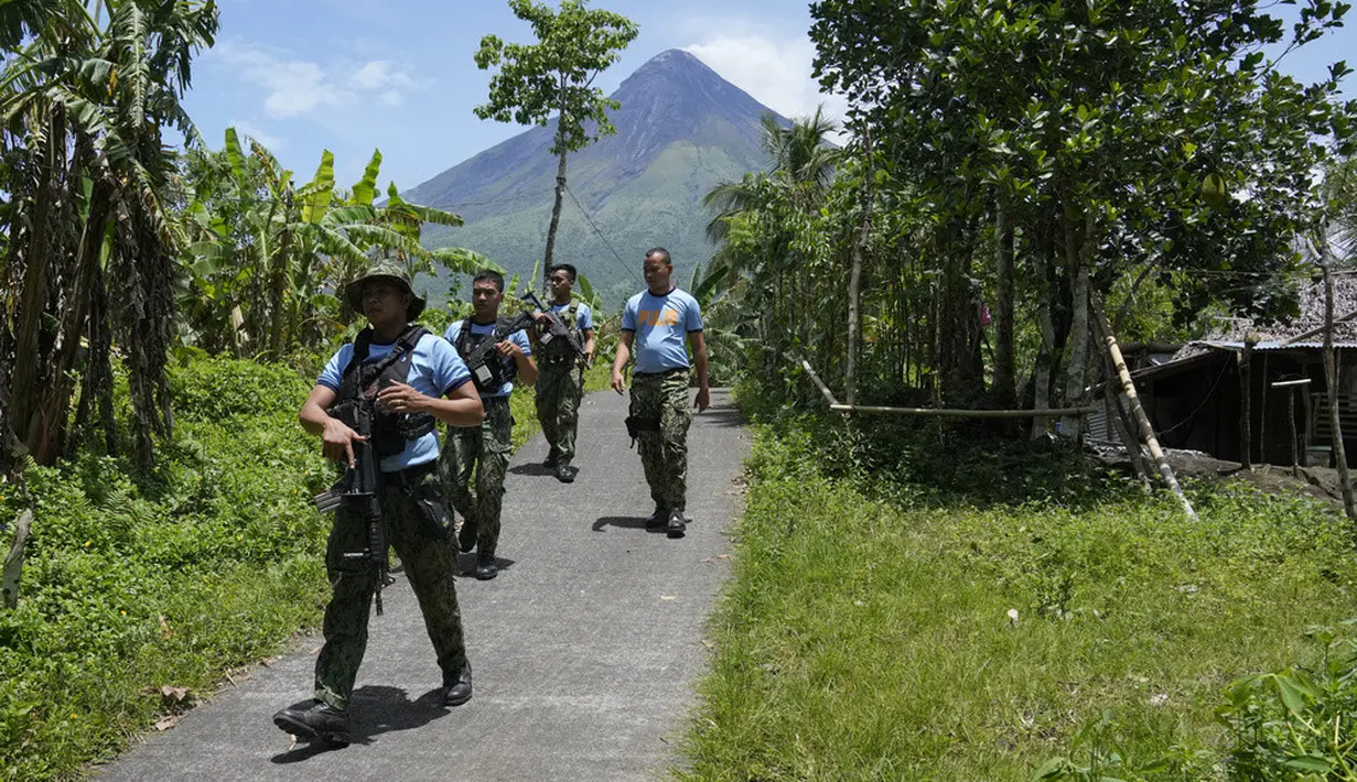 <p>Polisi melakukan patroli di "zona bahaya permanen" untuk memeriksa pengungsi yang kembali atau masih tinggal di rumah mereka di Desa Calbayog, Kota Malilipot, Provinsi Albay, Filipina, Kamis (15/6/2023). (AP Photo/Aaron Favila)</p>