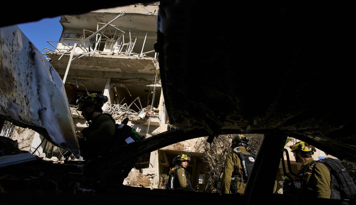 Pasukan keamanan Israel dan tim penyelamat memeriksa lokasi serangan rudal Iran di Tel Aviv, Israel, Selasa, 24 Maret 2026. Serangan rudal Iran kembali menghantam ibu kota Israel, Tel Aviv. (AP Photo/Oded Balilty)