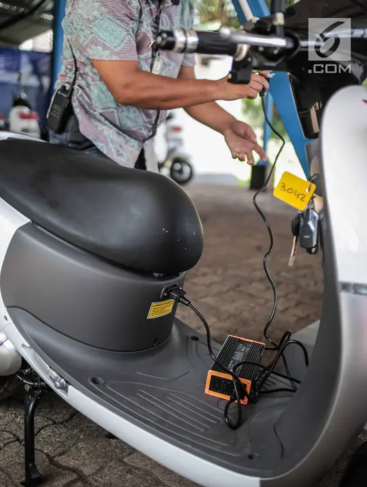 Petugas menunjukan pengisian daya motor listrik di Taman Marga Satwa Ragunan, Jakarta, Kamis (13/12). Pemprov DKI mulai menggunakan motor listrik di beberapa titik untuk mempercepat penggunaan kendaraan listrik di Indonesia. (Liputan6.com/Faizal Fanani)