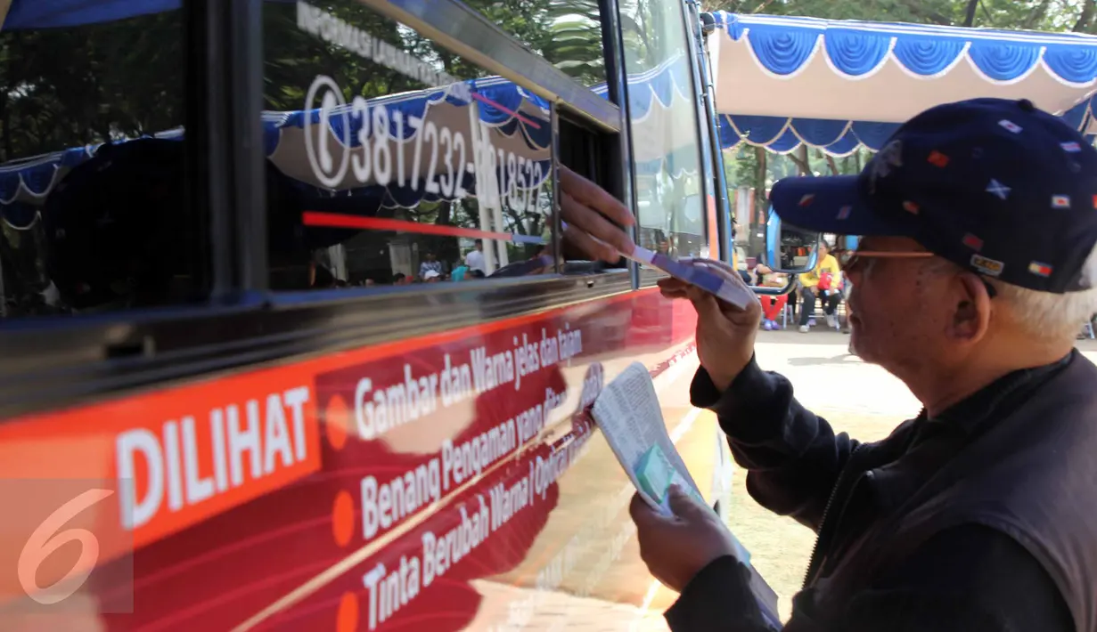 Warga menukarkan uang melalui layanan mobil kas keliling Bank Indonesia di Lapangan IRTI, Monas, Jakarta, Kamis (2/7). Sebanyak 15 bank membuka gerai penukaran uang pecahan hingga 15 Juli mendatang. (Liputan6com/Helmi Afandi)