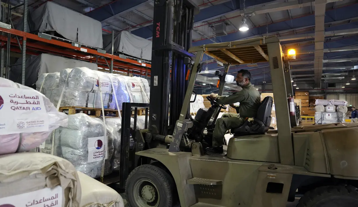 Pengemudi forklift memuat paket bantuan untuk dikirim ke daerah yang terkena gempa di Turki, di Pangkalan Udara Al-Udeid di Doha, Qatar, Selasa, 7 Februari 2023. Gempa bumi dahsyat melanda Turki tenggara dan Suriah Senin dini hari, merobohkan ratusan bangunan serta menewaskan dan melukai ribuan orang. (AP Photo/Kamran Jebreili)