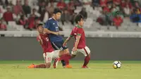 Pemain Timnas Indonesia U-19, Abimanyu (kiri) dan Lutfi Kamal (kanan) berebut bola dengan pemain Jepang U-19 di Stadion Utama GBK, (24/3/2018). Indonesia U-19 tertinggal sementara 0-1. (Bola.com/Nicklas Hanoatubun)
