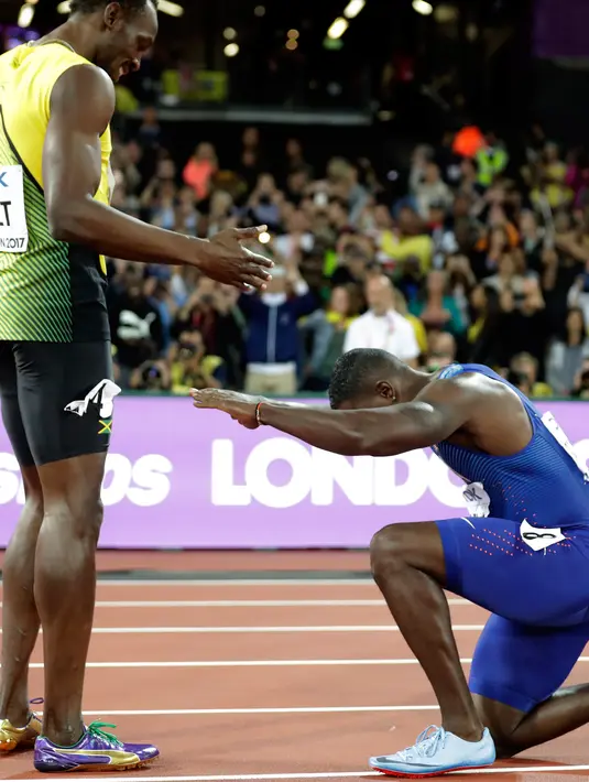 Pelari AS, Justin Gatlin berlutut di hadapan Usain Bolt usai menjadi juara pada lomba lari 100 meter Kejuaraan Dunia Atletik 2017 di Stadion London, Minggu (6/8). Gatlin menjadi pelari tercepat dengan catatan waktu 9.92 detik. (AP Photo/Matt Dunham)