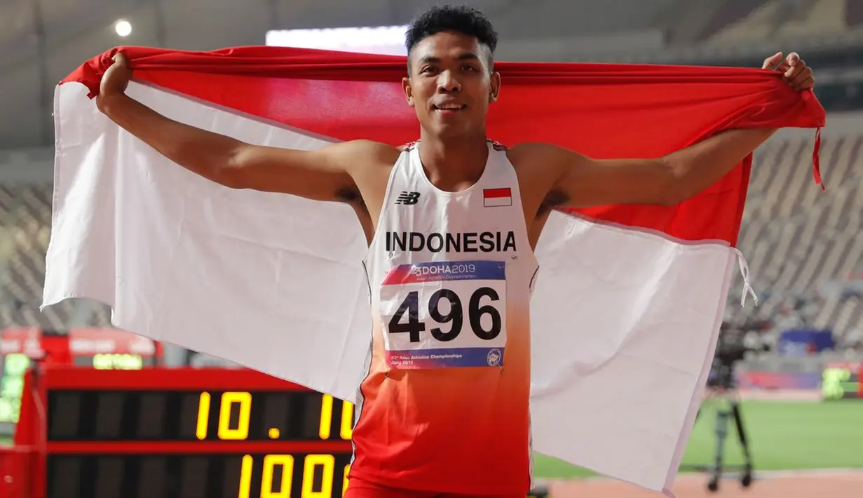 Sprinter Indonesia, Lalu Muhammad Zohri mengibarkan bendera Merah Putih seusai mengikuti kategori 100 meter dalam semifinal Kejuaraan Atletik Asia di Doha, Qatar, Senin (22/4/2019). Lalu Muhammad Zohri sukses menggondol medali perak setelah membukukan catatan waktu 10,13 detik. (AP/Vincent Thian)