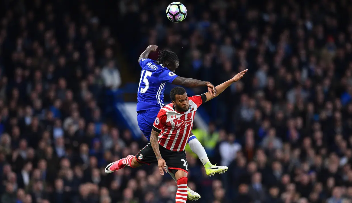 Gelandang Chelsea, Victor Moses, duel udara dengan bek Southampton, Ryan Bertrand, pada laga Premier League di Stadion Stamford Bridge, London, Selasa (25/4/2017). Chelsea menang 4-2 atas Southampton. (AFP/Glyn Kirk)