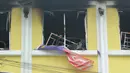 Bendera nasional Malaysia berada di luar jendela usai kebakaran di sekolah agama Darul Quran Ittifaqiyah, Malaysia (14/9). Menurut polisi setempat, siswa yang tewas semuanya laki-laki yang berusia antara 13 hingga 17 tahun. (AFP Photo/Sadiq Asyraf)