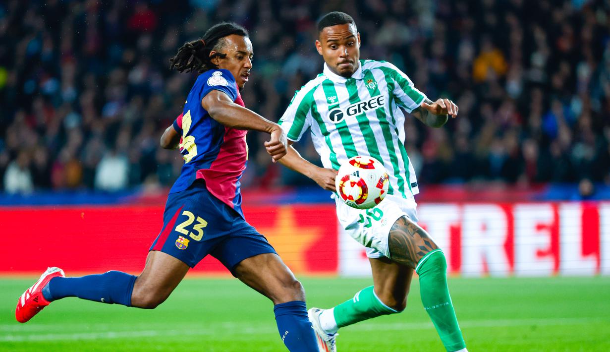 Pemain Barcelona, Jules Kounde, mencetak gol ke gawang Real Betis pada laga babak 16 besar Copa del Rey 2024/2025 yang dihelat di Estadi Olimpic Lluis Companys, Kamis (16/1/2025) dini hari WIB. (AFP/Manaure Quintero)