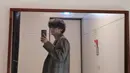 Busana setelan oversize yang digunakan oleh V saat melakukan mirror selfie ini membuat penampilannya semakin memesona. Dirinya pun terlihat menata rambut dengan cukup sederhana serta memakai sandal rumah berwarna hitam. (Liputan6.com/IG/@thv)