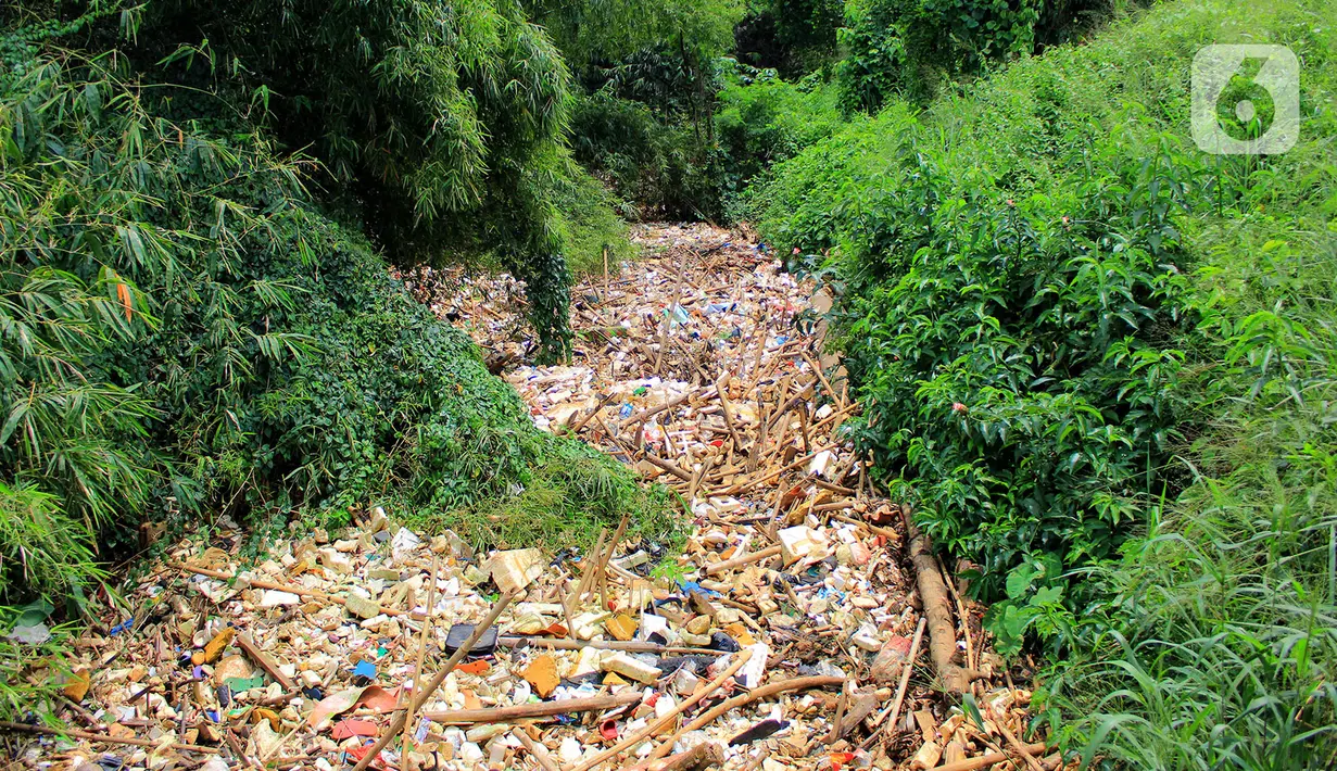 Pemandangan sampah yang memenuhi Kali Baru di Jalan Pitara Raya, Depok, Jawa Barat, Rabu (19/2/2020). Warga kerja bakti mengangkut sampah dari kali agar aliran sungai tetap lancar. (merdeka.com/Magang/Muhammad Fayyadh)