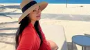 Titi Kamal pilih dress linen merah untuk tampil nyaman saat nikmati pantai. Dilengkapi dengan topi rotan yang melindungi rambutnya dari sinar matahari [@titi_kamall]