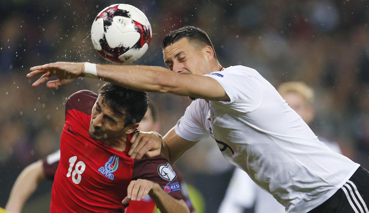 Striker Jerman, Sandro Wagner, duel udara dengan bek Azerbaijan, Tamkin Khalilzade, pada laga kualifikasi Piala Dunia di Stadion Fritz Walter, Minggu (8/10/2017). Jerman menang 5-1 atas Azerbaijan. (AP/Michael Probst)