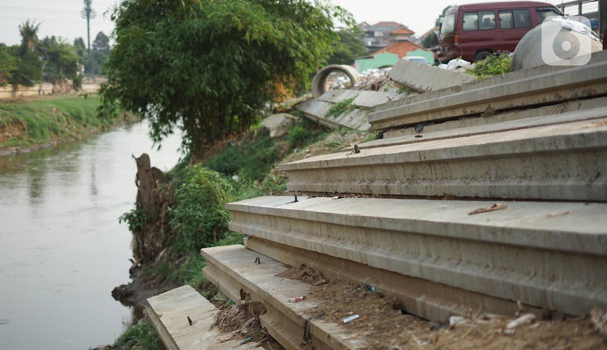 Tiang pancang dan saluran gorong-gorong menghiasi bantaran Sungai Ciliwung di kawasan Rawajati, Jakarta, Rabu (30/10/2019). Tiang-tiang pancang itu merupakan sisa proyek normalisasi Sungai Ciliwung dan telah berada di bantaran tersebut selama beberapa tahun terakhir. (Liputan6.com/Immanuel Antonius)
