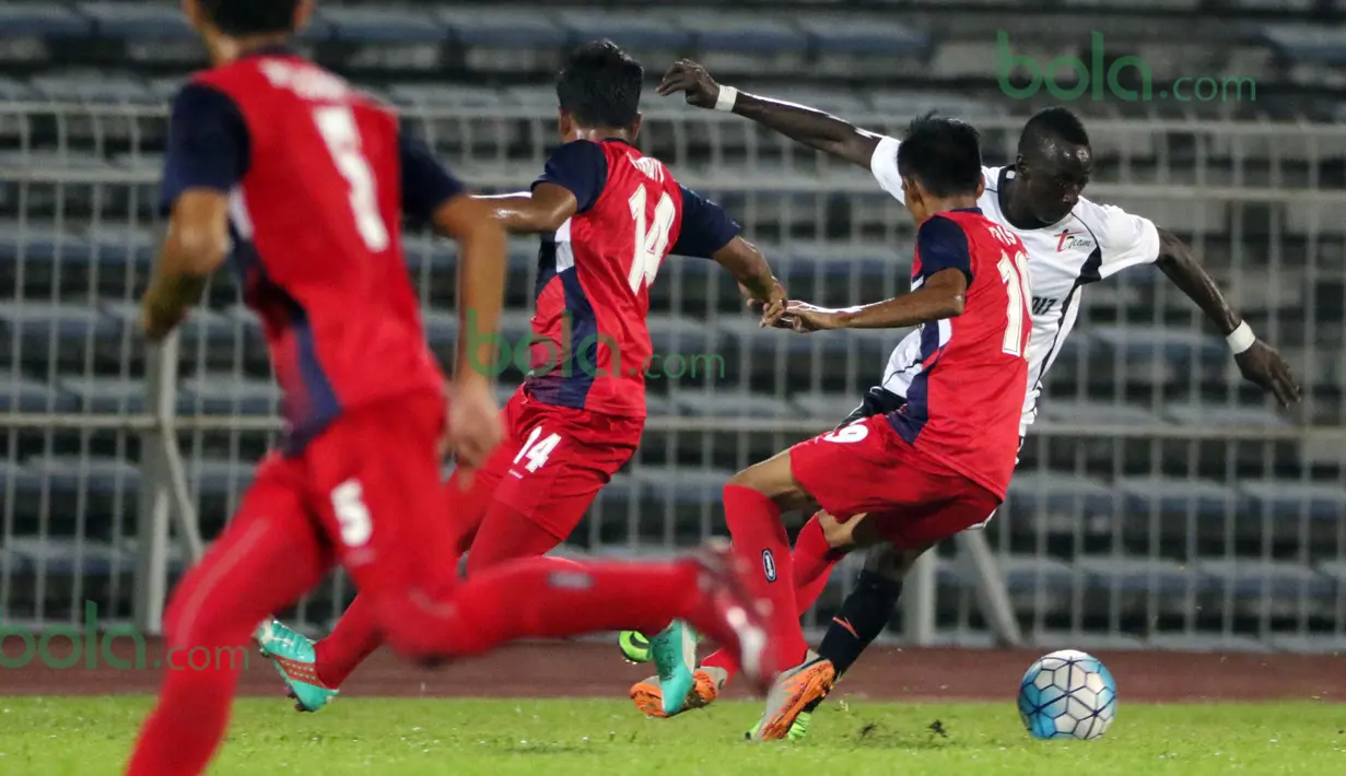 Gelandang T-Team Malaysia, Makan Konate, dihadang pemain ATM FA pada laga play-off Malaysia Super League 2016. (Bola.com/Nicklas Hanoatubun)