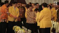 Wakil Presiden Jusuf Kalla (tengah) didampingi Ketum Golkar Airlangga Hartarto saat menghadiri penutupan Munaslub Golkar di Jakarta, Rabu (20/12). Jusuf Kalla mengenakan batik berwarna emas saat menghadiri acara tersebut. (Liputan6.com/Faizal Fanani)