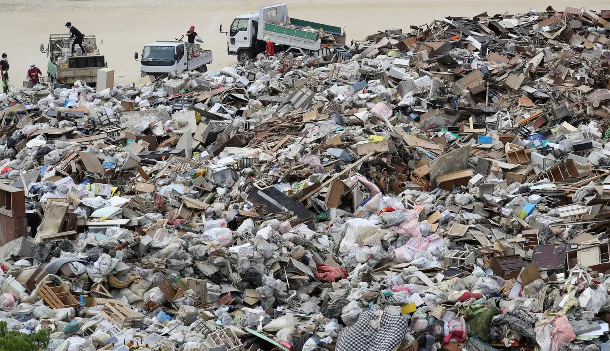 Tempat pembuangan sampah dipenuhi puing-puing usai banjir yang menerjang Kurashiki, Prefektur Okayama, Jepang, Rabu (11/7). Warga menyekop lumpur dan puing-puing untuk membersihkan jalan-jalan. (Takaki Yajima/Kyodo News via AP)